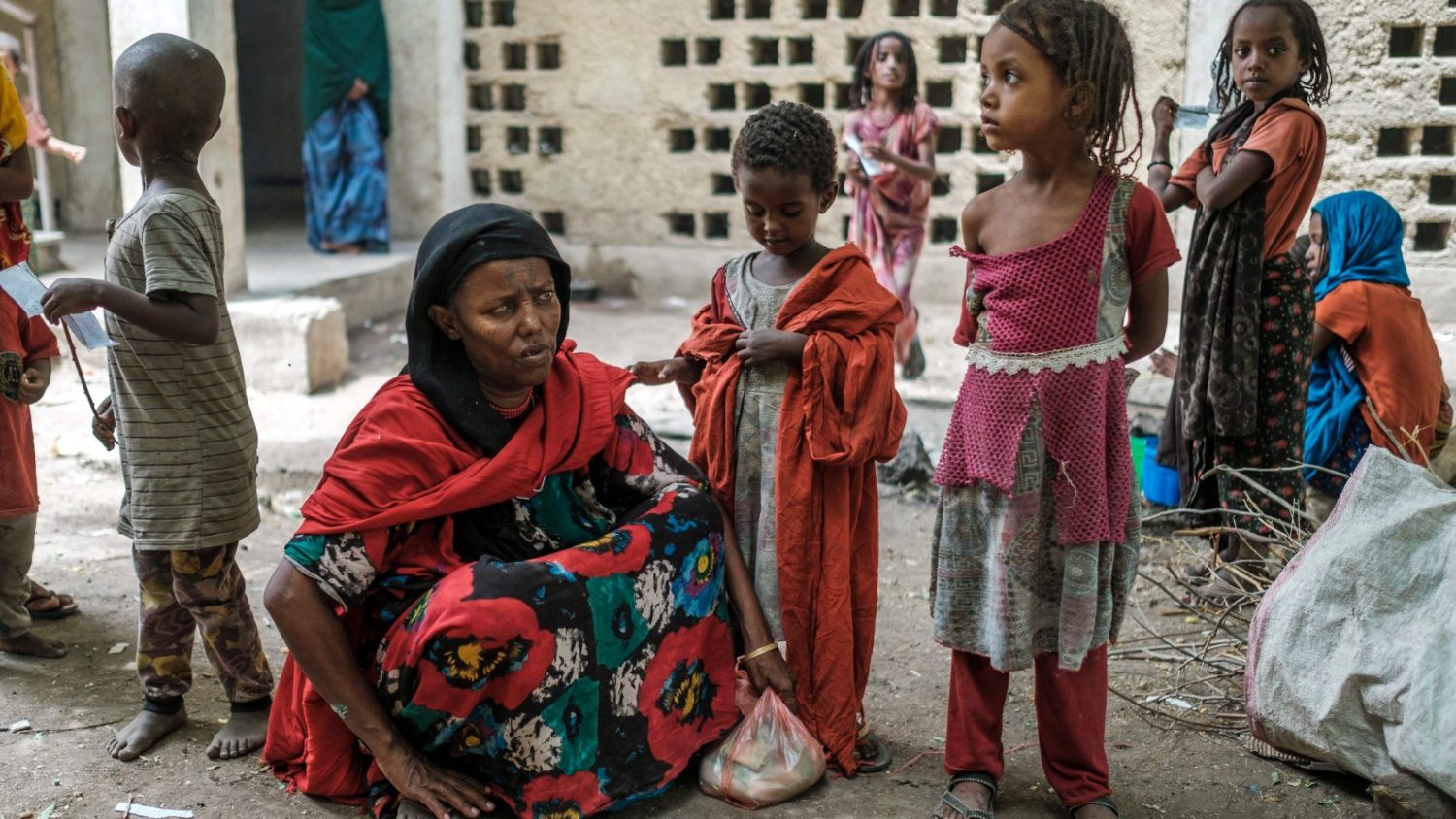 Medina Ahmed, uno sfollato di Konaba, siede con i bambini in un complesso di edifici abbandonati che ospitano gli sfollati vicino alla città di Dubti, a 10 chilometri da Semera, in Etiopia. Più di un milione di persone ha bisogno di aiuti alimentari nella regione secondo il Programma alimentare mondiale. (Foto di EDUARDO SOTERAS/AFP)