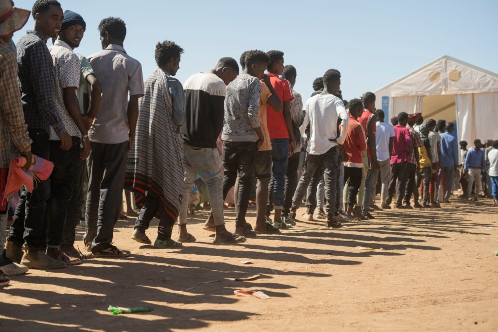 I rifugiati etiopi provenienti dalla regione del Tigray attendono di ricevere aiuti nel campo profughi di Um Rakuba, a circa 80 km dal confine tra Etiopia e Sudan in Sudan, il 30 novembre 2020. Secondo il Programma alimentare mondiale, il 2 dicembre, circa 12.000 rifugiati etiopi provenienti dal Tigray sono stati sono stati accolti nel campo di Um Rakuba mentre oltre 40.000 rifugiati etiopi sono fuggiti in Sudan dall'inizio dei combattimenti nella regione settentrionale del Tigray in Etiopia. (Foto: EPA-EFE / Ala Kheir)