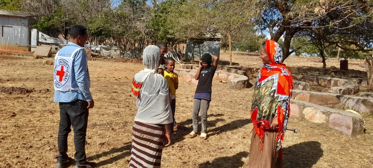 Un membro del personale della Croce Rossa Internazionale (CICR) osserva un residente che parla alla famiglia su un telefono satellitare nel Tigray, in Etiopia. Comitato Internazionale della Croce Rossa/Dispensa tramite Thomson Reuters Foundation