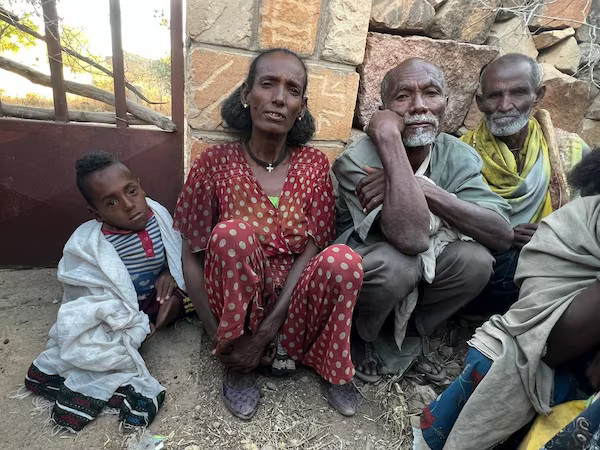 Haregwein Fitsum aspetta gli aiuti alimentari con il figlio disabile, il marito e un contadino. Dice che la famiglia a volte resta senza cibo per giorni.